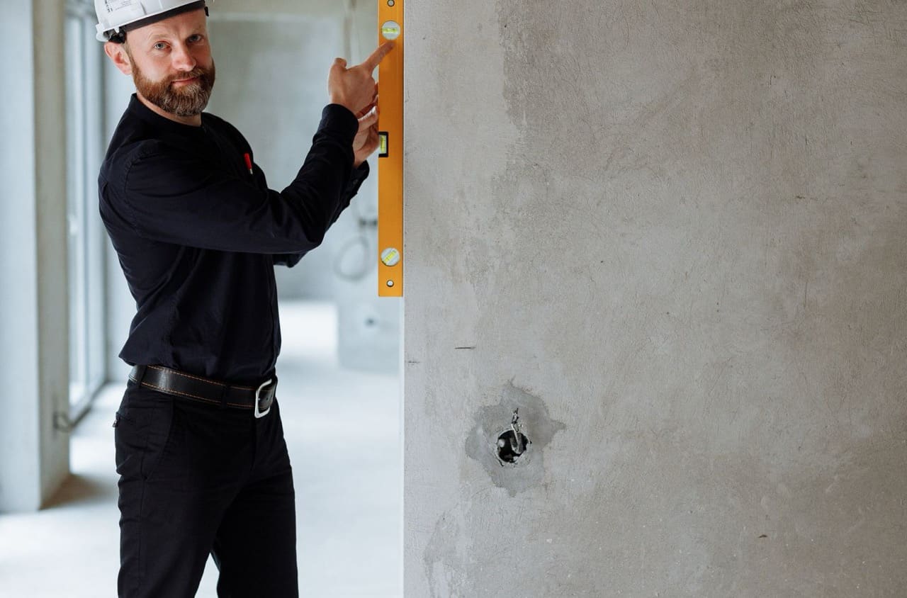 Monteur prüft eine Wand mit der Wasserwaage