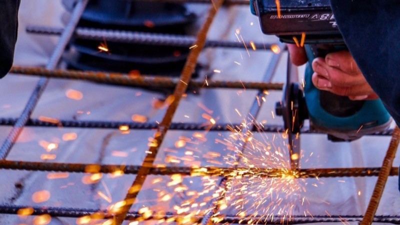 Handwerker trennt Stahl mit dem Winkelschleifer
